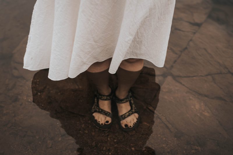 Girl waring sandals with her feet under water