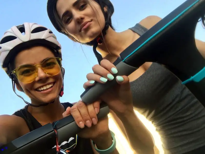Two girls taking a selfie on electric scooters