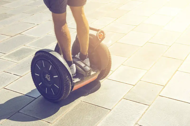 Man riding a Segway on a paved surface