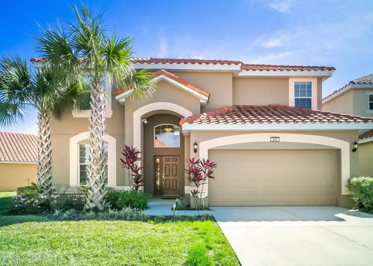 Large home with two car garage and palm tree in front yard at Aviana Resort