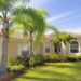 Beautiful Florida home with green grass and palm trees on a sunny day