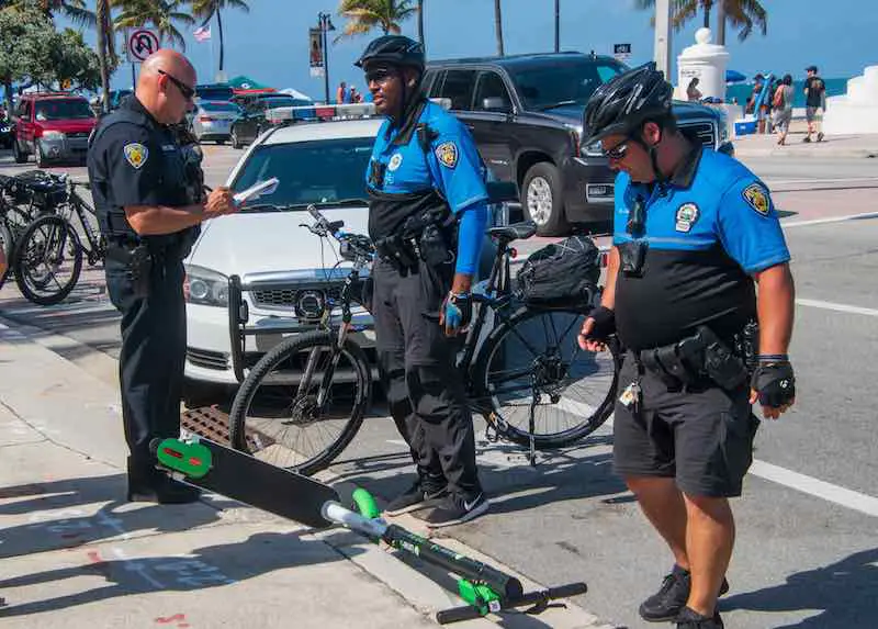 Police officers investigate an electric motor scooter accident on the street by the beach in Ft Lauderdale, Florida.