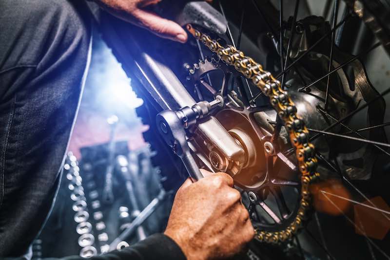 Man fixing a dirt bike chain