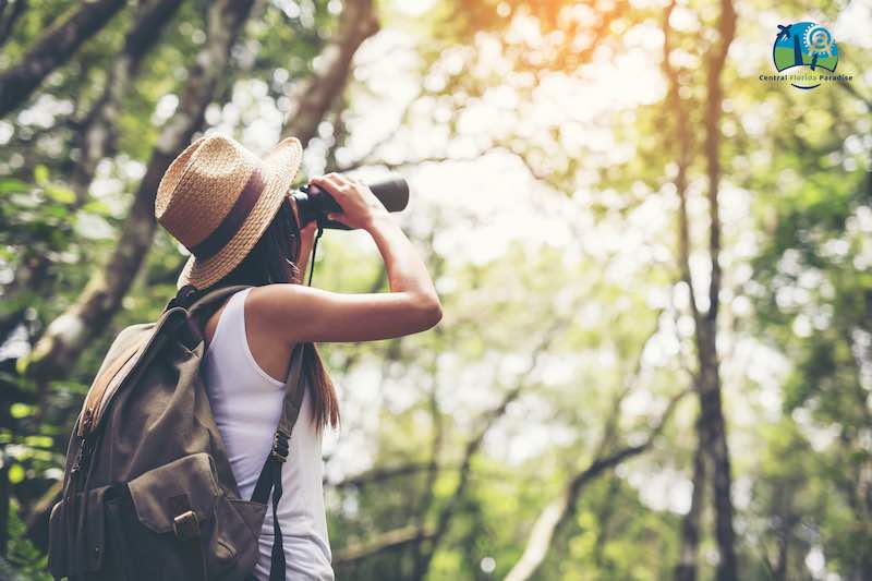Young Lady With a Backpack looking through a binocular