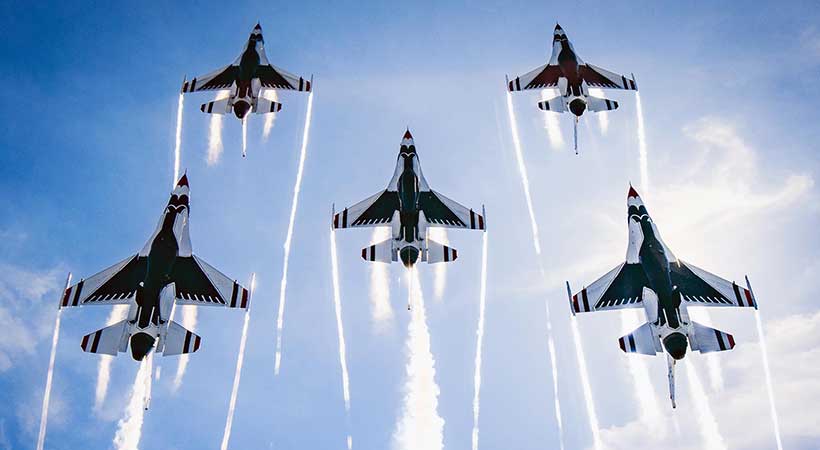 View of the underbelly of the US Airforce Thunderbirds flying overhead in a formation of 5 jets.