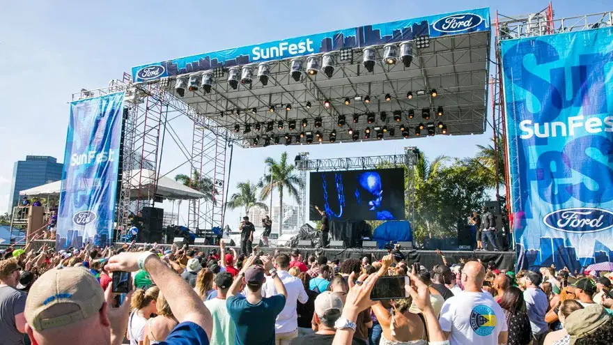 Crowd of festival goers around a large stage with musical artists performing