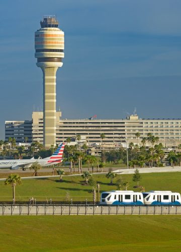 Orlando International Airport North terminal with airplane and people mover in the foreground