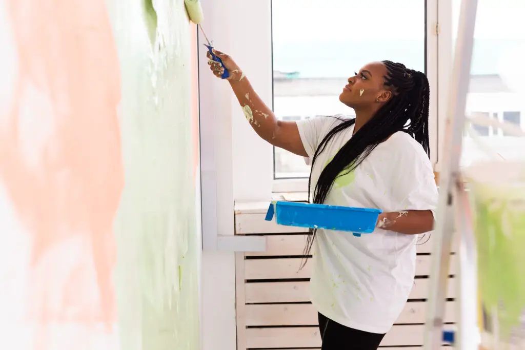 Woman painting interior walls of a home